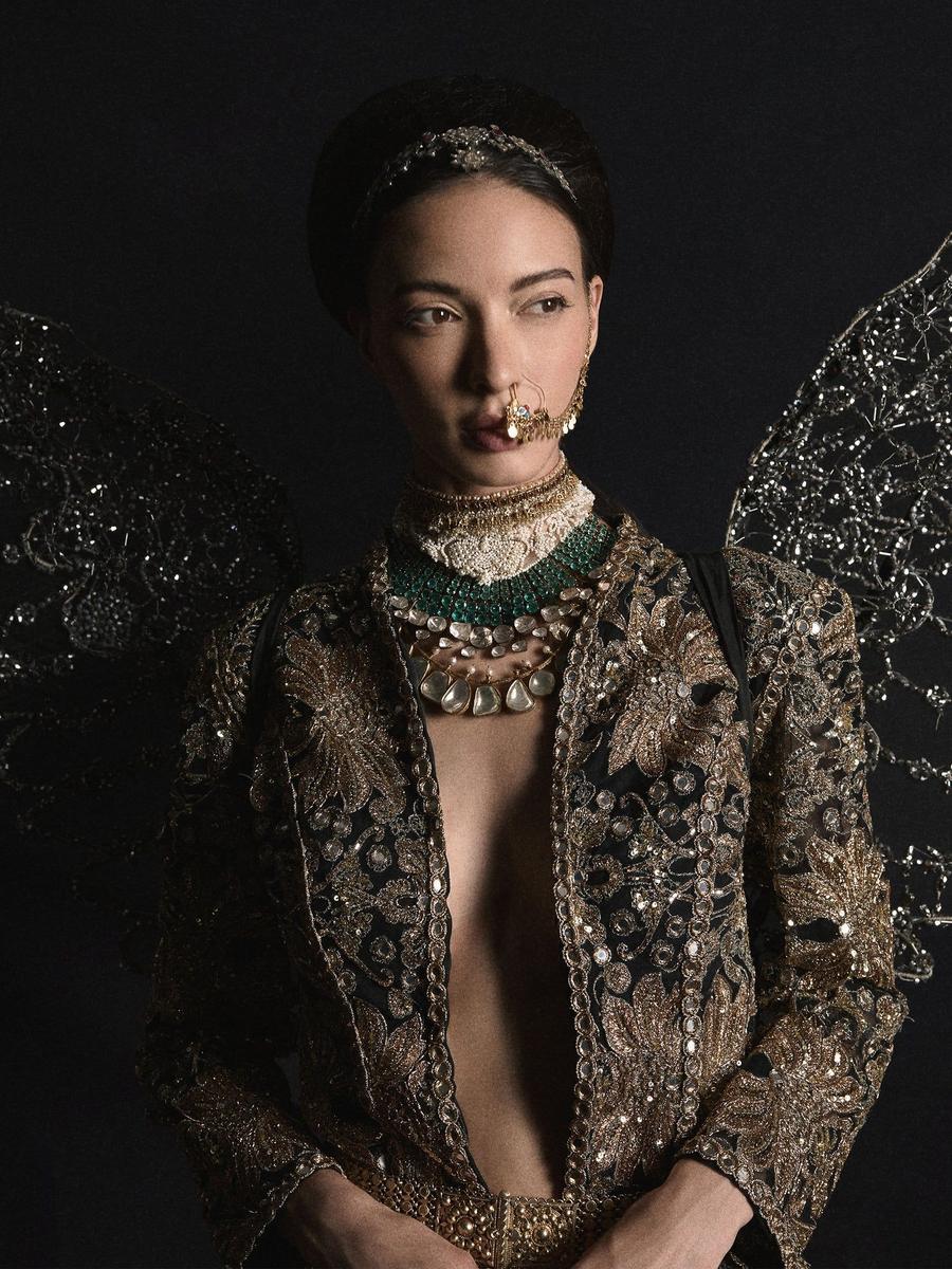 A dark jacket worked in gold thread, photographed close against a black ground