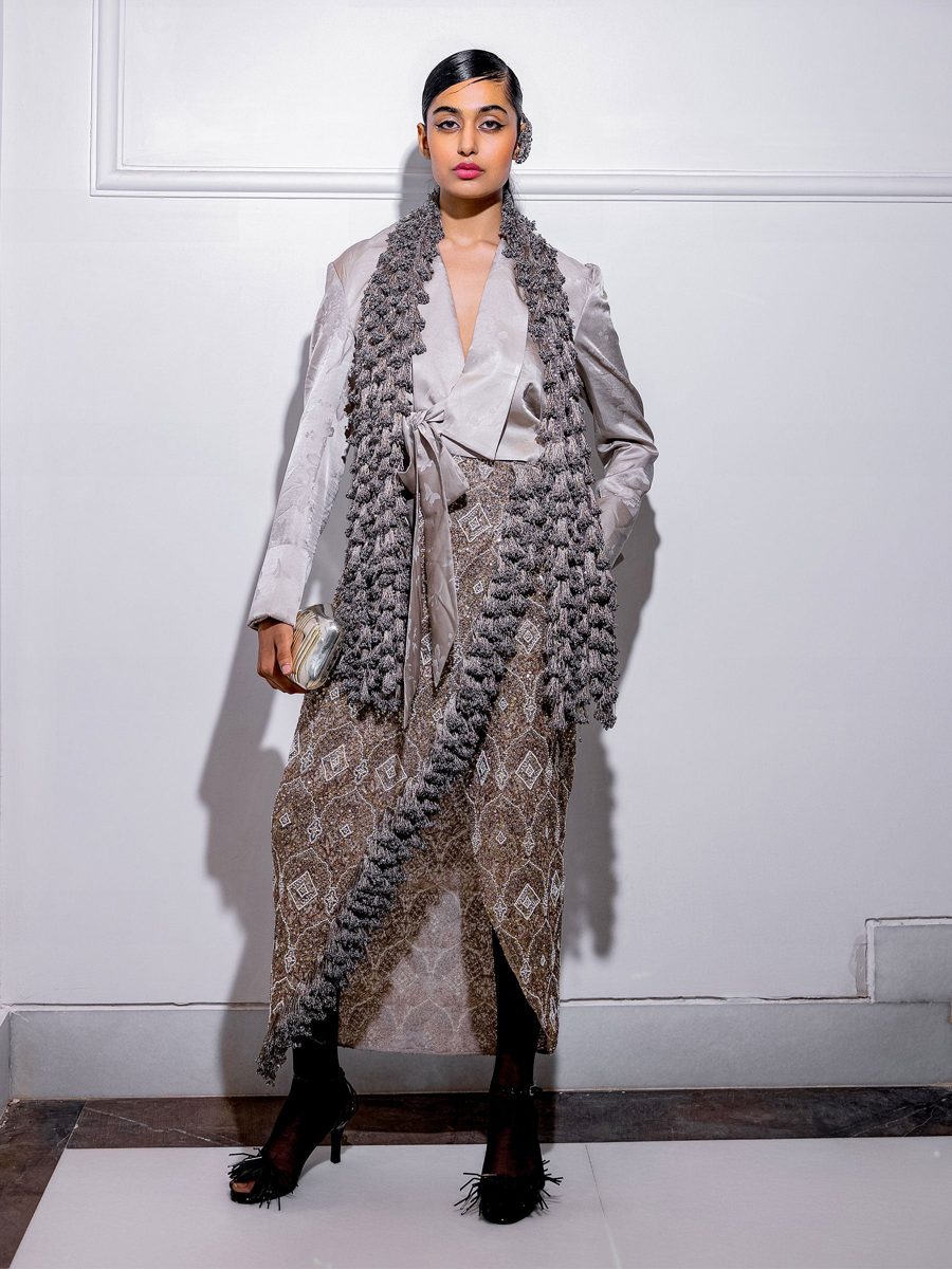 A sculpted gold-toned cape jacket over a wide tulle skirt