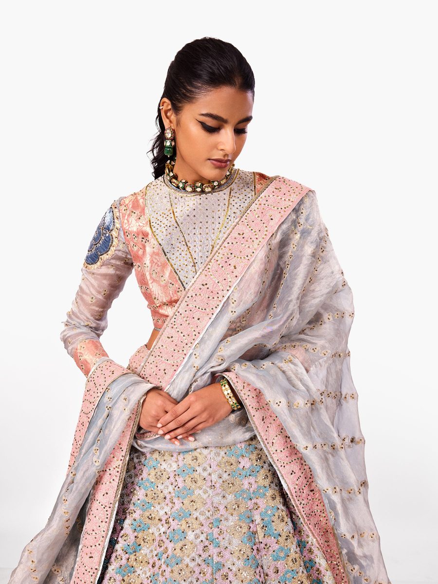 A lehenga with a pastel patchwork skirt and a silver organza dupatta