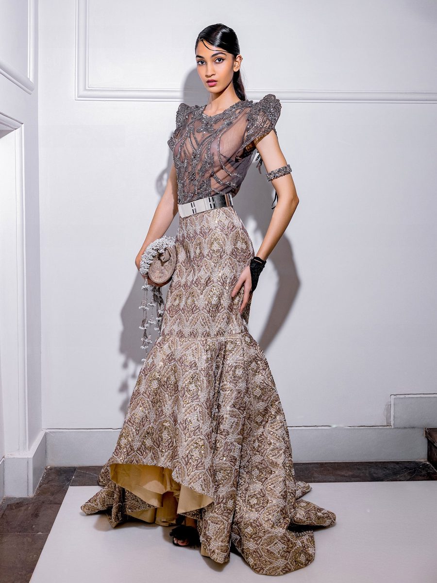 A beaded fitted gown with a structured shoulder and gold lining