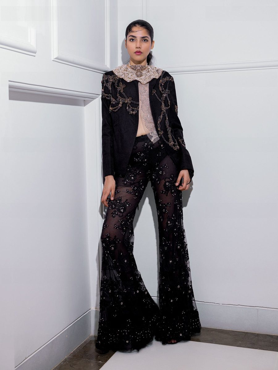 A black embroidered jacket over flared trousers
